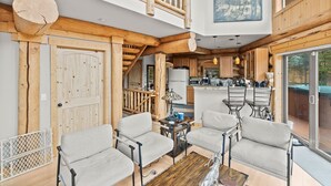 A modern log cabin interior with a dining area, kitchen, and a balcony with a view. - NEW LISTING | 4BD Log Home in Twin Lakes, Amazing Views, Pets OK (Twin Lakes)