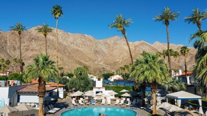 A pool area with lounge chairs and umbrellas, palm trees, and a mountain backdrop. - Santa Rosa Cove #61 - 3 bedrooms, 3.5 Baths (La Quinta)