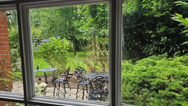 Eine Terrasse mit Gartenmöbeln und einer Backsteinmauer.