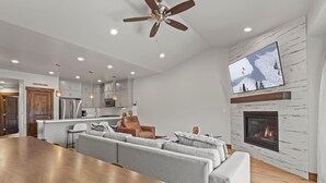 A modern living room with a fireplace, a large TV mounted on the wall, and a cozy seating area. - Moose Mgmt at Black Rock 14442: Fully Equipped Kitchen-Pvt Hot Tub-Dogs Welcome (Park City)
