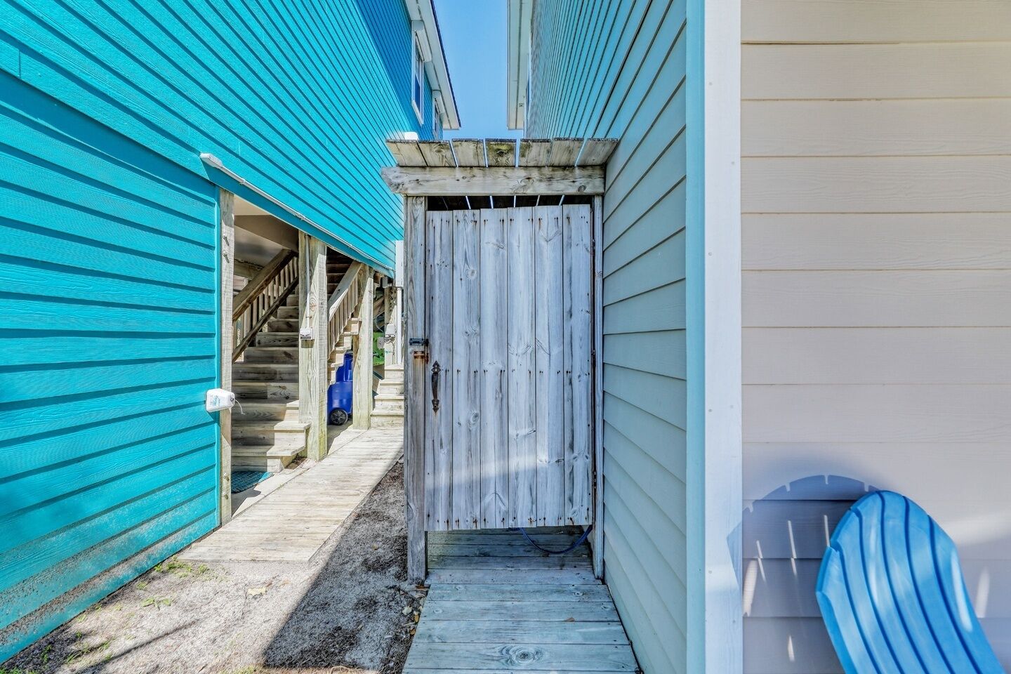 A narrow wooden pathway leading to a building with a wooden door.