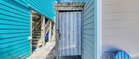 A narrow wooden pathway leading to a building with a wooden door.