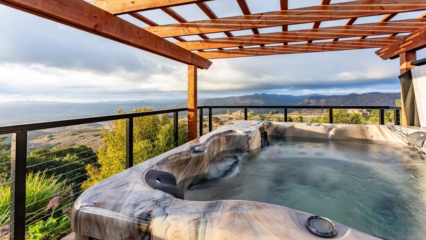 A hot tub with a wooden pergola overhead, surrounded by a scenic mountain view. - San Diego Wine Country Pool, Views, 4BR (Ramona)