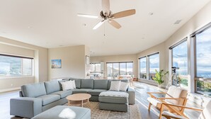 A spacious living room with a large sectional sofa, a round coffee table, and a ceiling fan. - San Diego Wine Country Pool, Views, 4BR (Ramona)