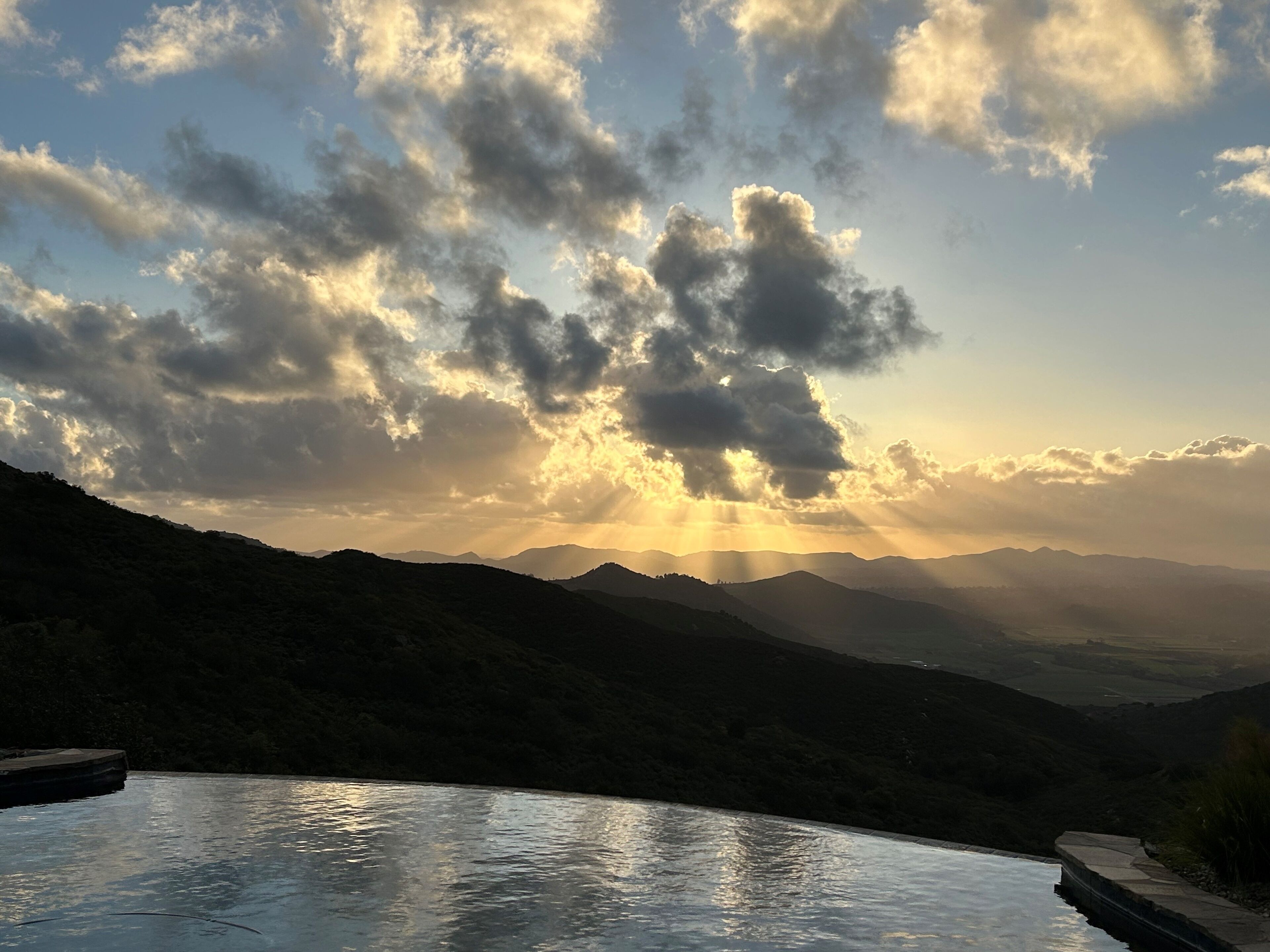 A mountainous landscape with a pool reflecting the sky.
