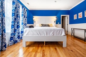 Relax in this serene bedroom with a large bed, reading lamps, and a small table.