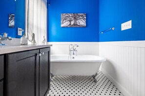 Bathroom features a bathtub, a cabinet, and a mirror.