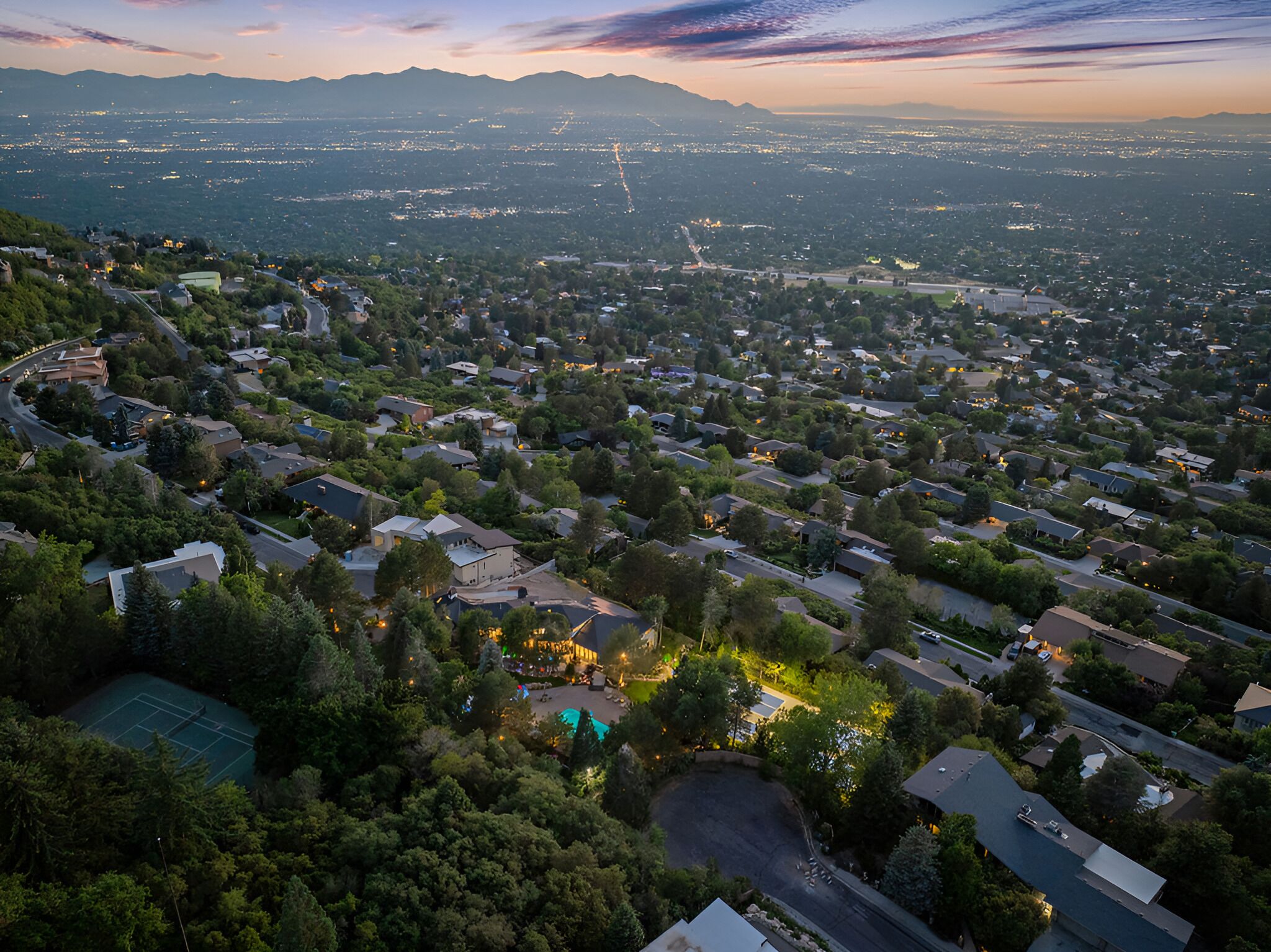 Vista aérea de una zona residencial con casas, calles y un paisaje urbano lejano.