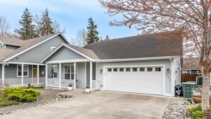 A two-story house with a garage, a covered porch, and a driveway.