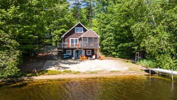 Situated by a serene lake, this cabin offers a balcony with outdoor seating and a dock for boat access.