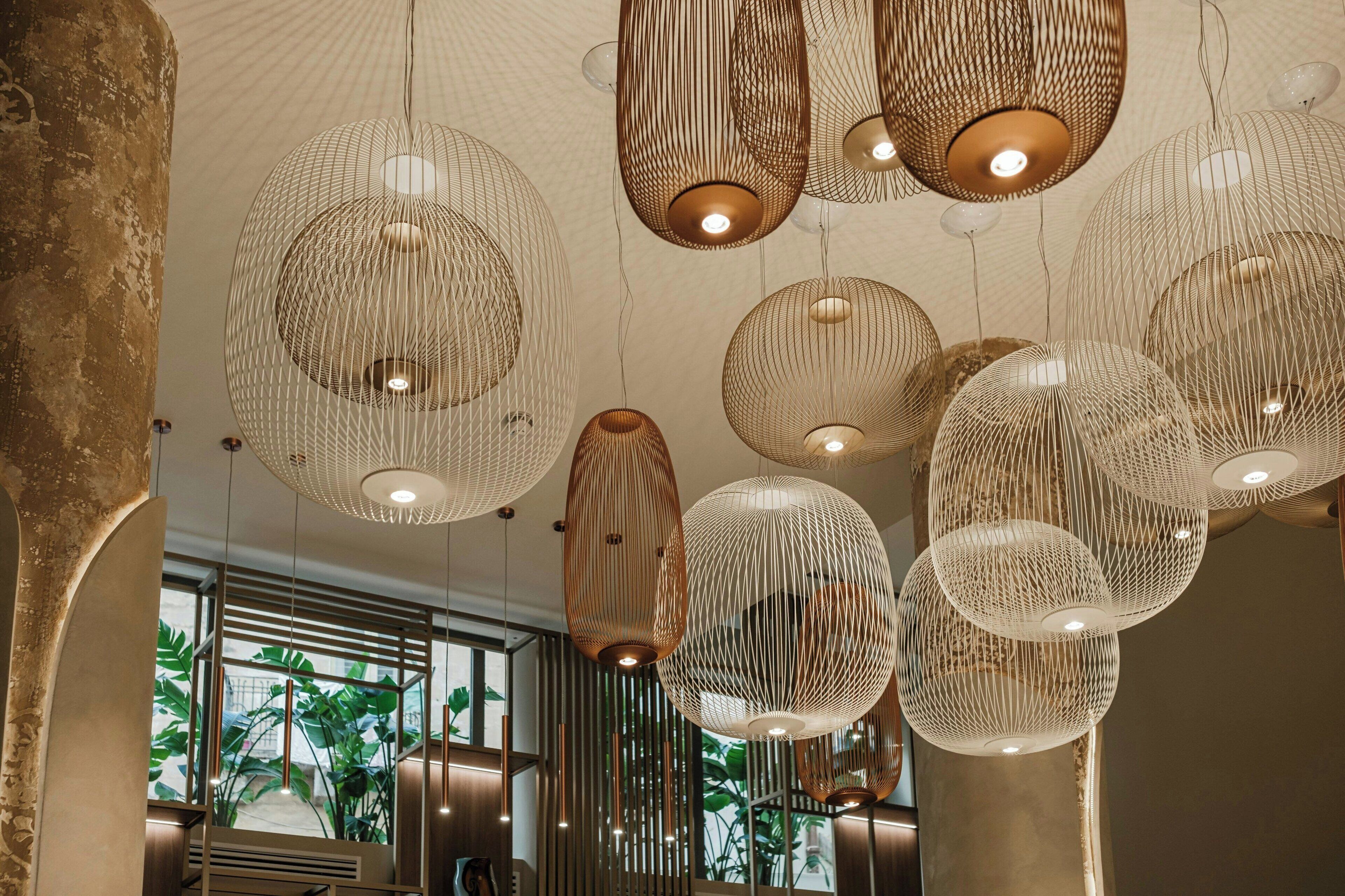 Un interno moderno con lampade sferiche a sospensione e vista sul verde circostante.