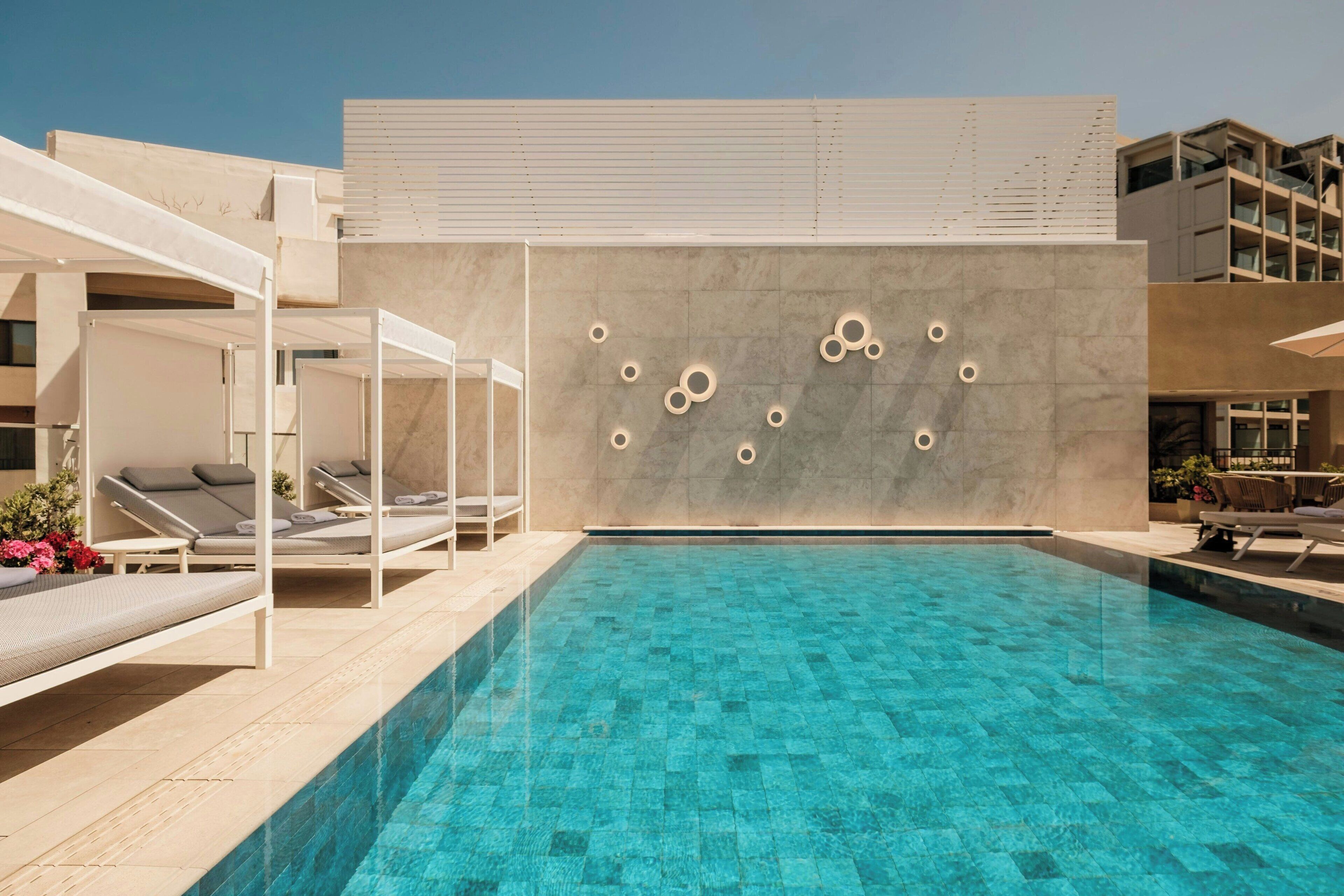 Area piscina moderna con sedie a sdraio e design minimalista.