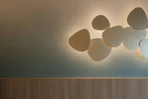 A wall with a textured surface and a wooden panel at the bottom. - Courtyard by Marriott Sliema (Sliema)