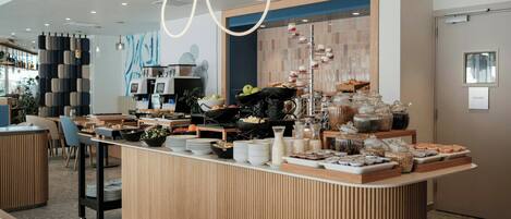 A modern breakfast bar with a variety of food items and beverages, a private room sign, and a contemporary interior design.
