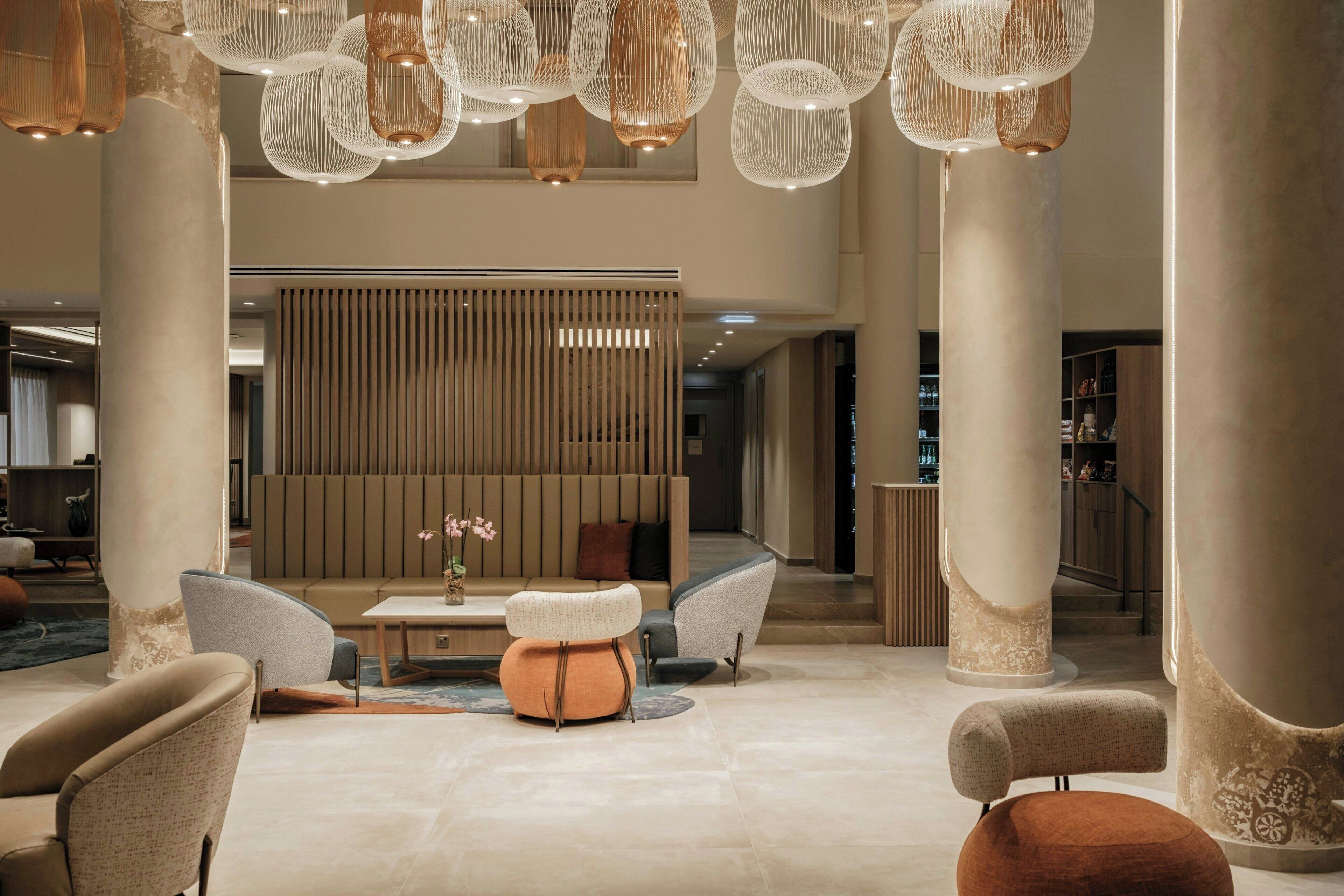 A spacious lobby with high ceilings, large columns, and modern seating arrangements.