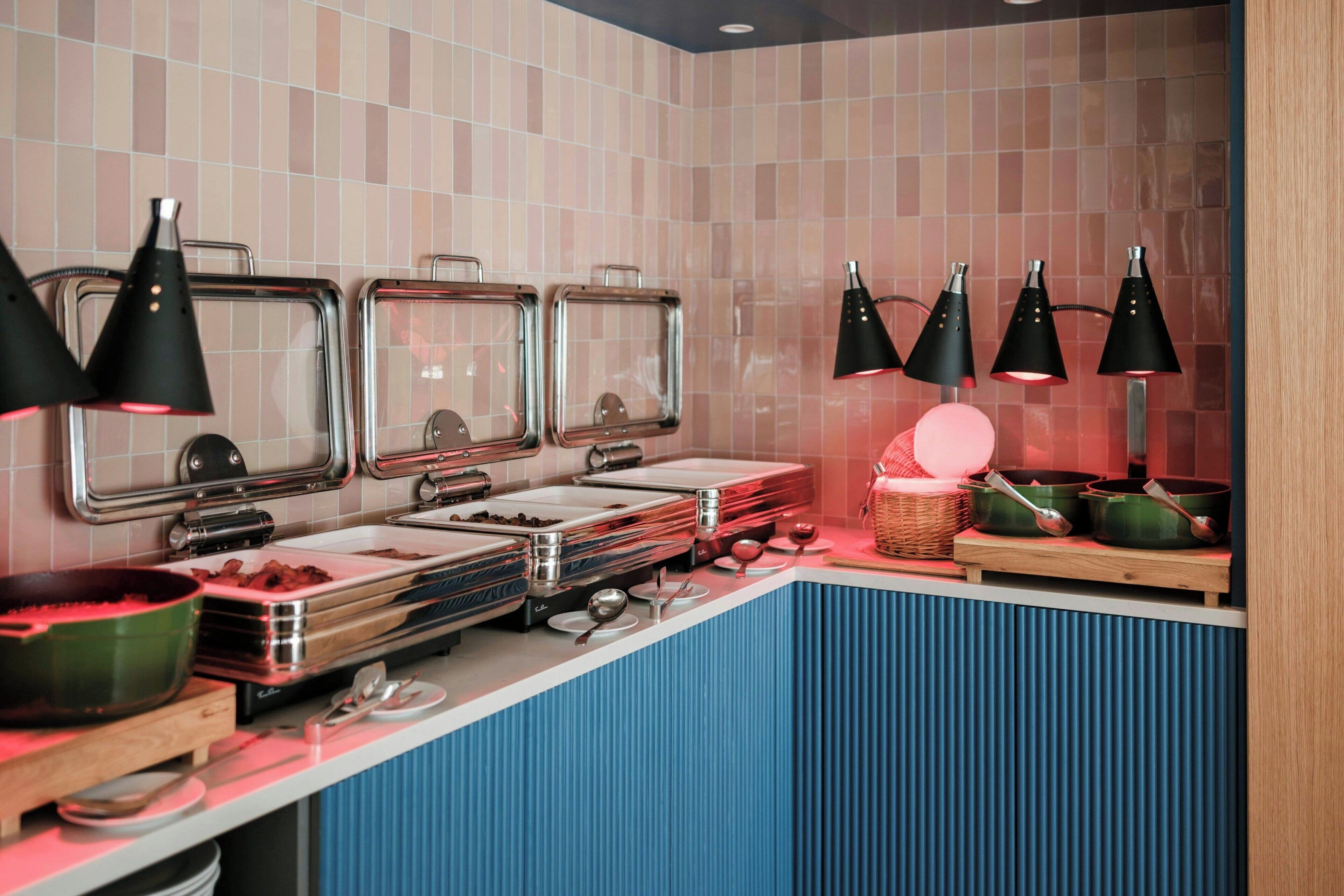 A buffet setup with multiple serving stations, including a variety of food containers and utensils.