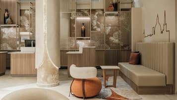 A modern hotel lobby with a reception desk, seating area, and decorative elements.