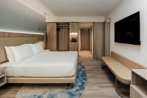 Relax in a spacious room with a large bed, bench, and flat-screen TV.