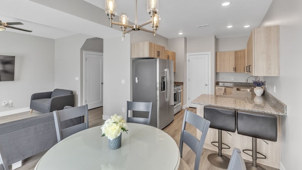 A modern kitchen with a central island, stainless steel appliances, and a chandelier. - The Ideal Getaway 3 Bedroom Home by RedAwning (Cedar City)