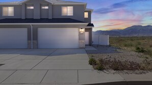 A modern two-story house with a garage, a driveway, and a view of mountains in the background. - The Ideal Getaway 3 Bedroom Home by RedAwning (Cedar City)