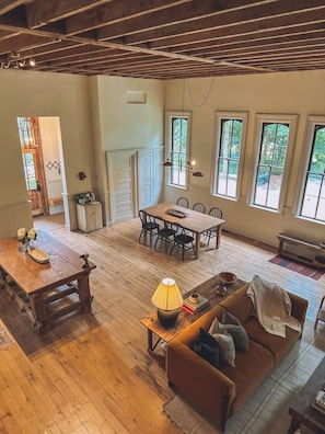 Una habitación amplia con una mesa de comedor de madera, un sofá y una lámpara.