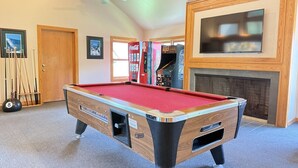 A pool table in a room with a fireplace, a ceiling fan, and framed pictures on the wall. - BeaverBox AC, Pool, Hot Tub, Sauna, Near Resort (Killington)