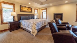 A bedroom with a bed, a nightstand, a desk, and a chair. - Beautiful New Home with Views of Castle Mountain - 3510 (Estes Park)