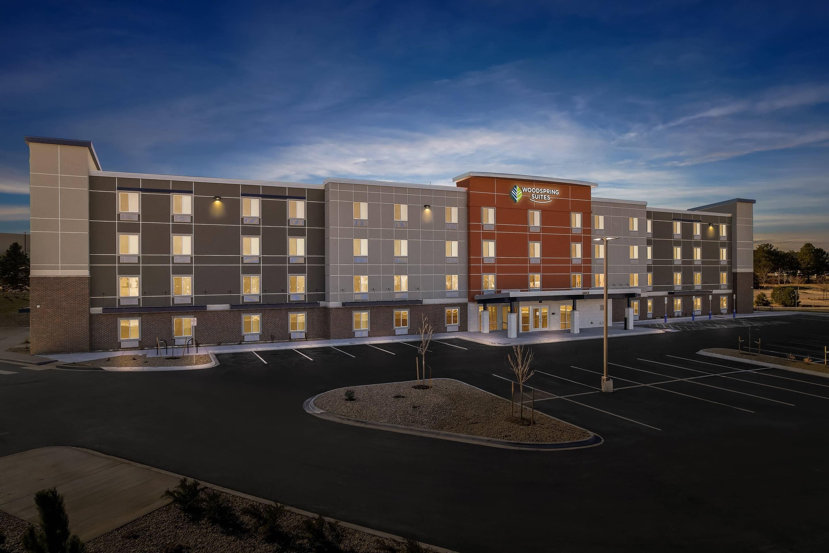 A multi-story hotel with a modern design, featuring a prominent logo on the facade.