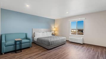 A bedroom with a bed, a chair, a nightstand, a window with a view, and a radiator.