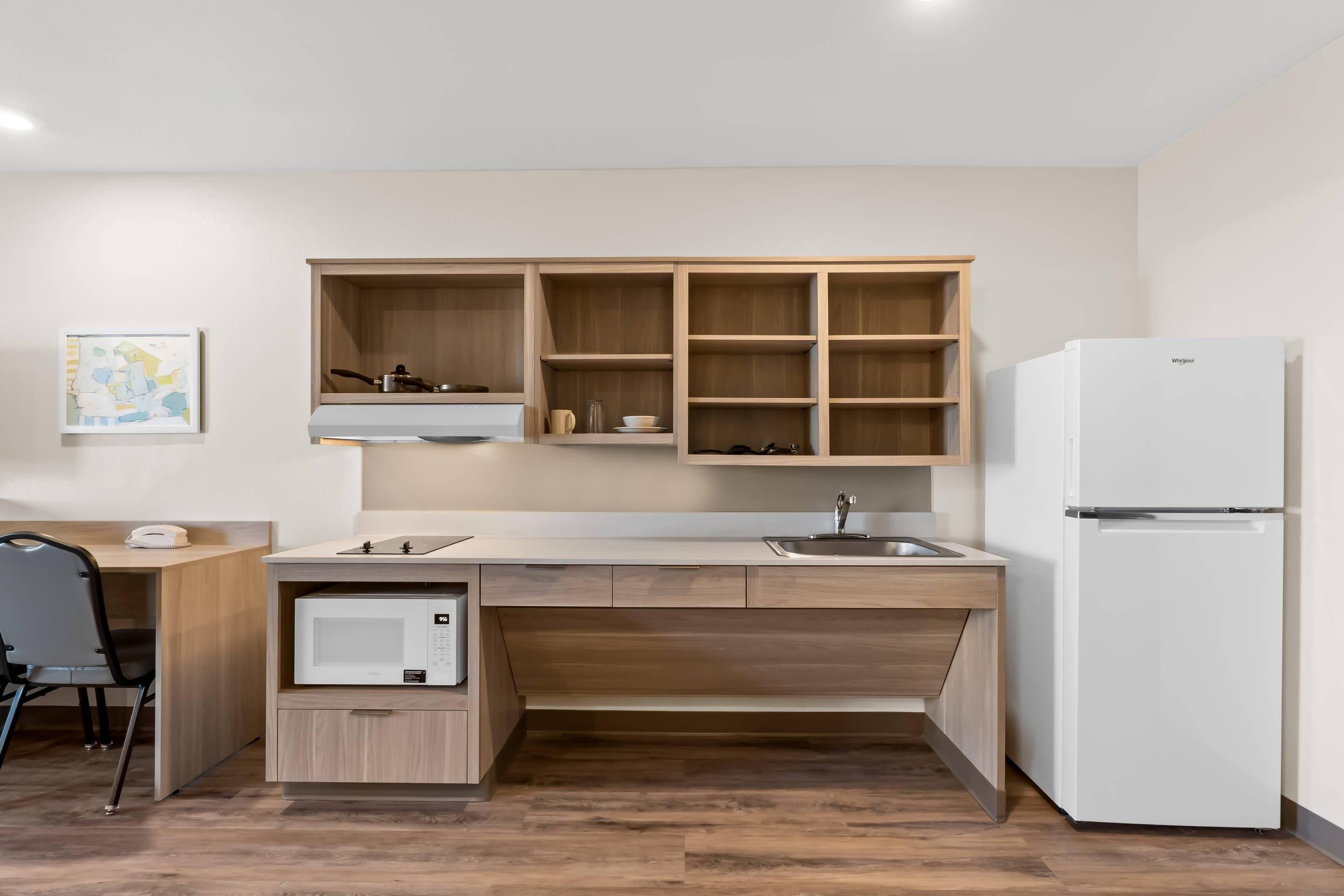 A compact kitchen with a built-in microwave, a sink, and a refrigerator.