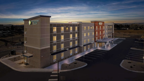 A multi-story hotel with a modern design, featuring a prominent logo on the facade. - WoodSpring Suites Centennial - Denver Tech Center (Centennial)
