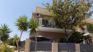 A multi-story building with balconies, palm trees, and a parked car. - Central Cute 2Bd Balcony apt in Skiathos (Skiathos)