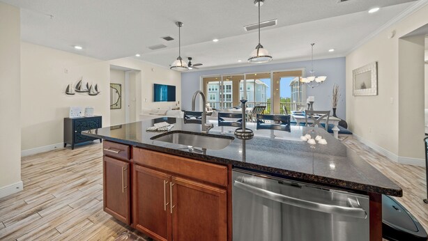 A modern kitchen with a large island, stainless steel appliances, and pendant lighting. - Waterfront Condo with Lanai and Pool, Near AMI Beaches and Marina (Bradenton)