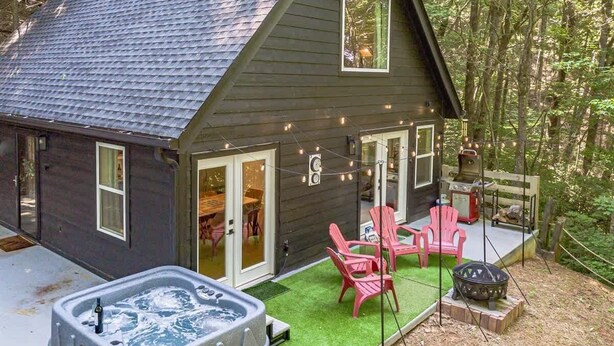A cabin with a hot tub, outdoor seating, and a deck. - RIDGEVIEW RETREAT | HOT TUB | FIRE PIT AND GAMES (Clarkesville)