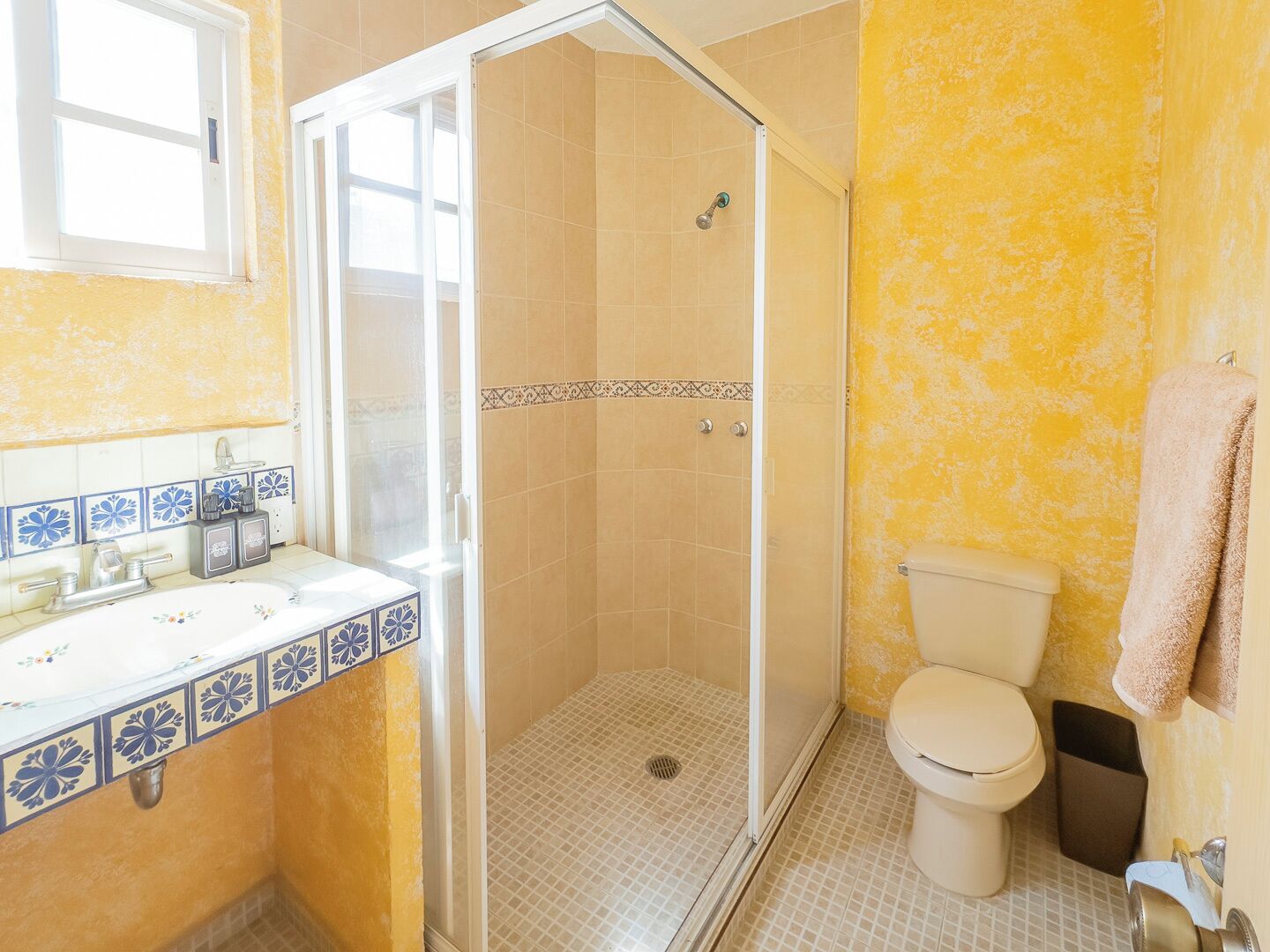 A bathroom with a shower, toilet, and sink.