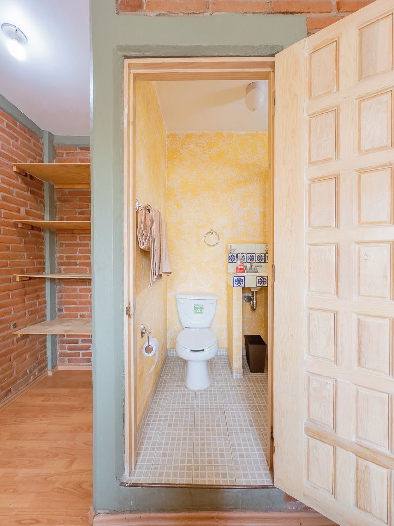 A bathroom with a toilet, a sink, and a shower area.