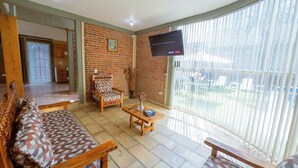 A living room with a sofa, armchairs, a TV, and a view of the outside. - New Family House. Pool & BBQ Area (Yautepec)