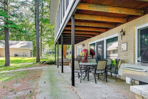 Eine Außenpatio mit überdachter Sitzgruppe, einem Grill und Blick auf eine Wohngegend.