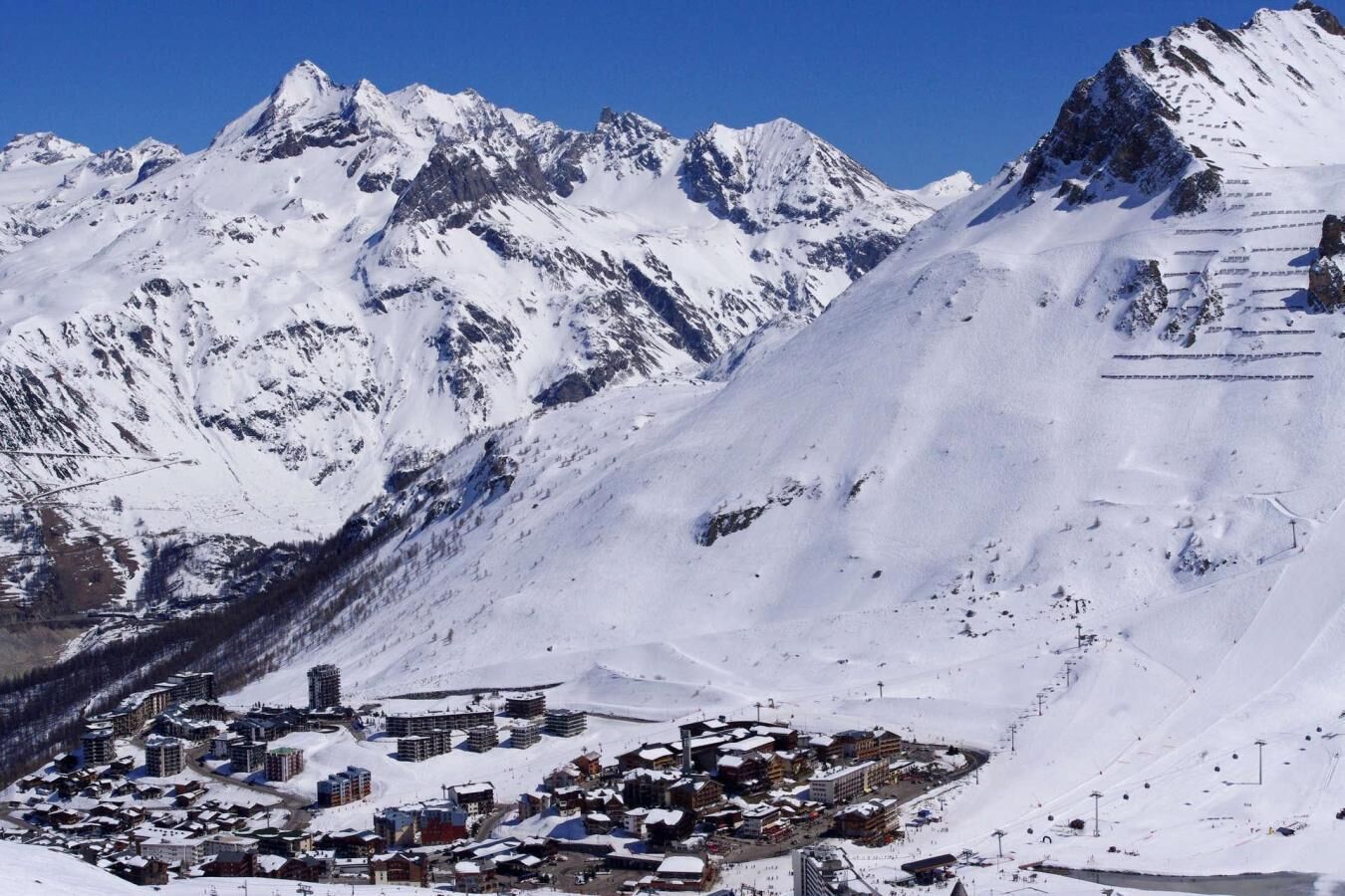 Une ville de montagne enneigée, avec des bâtiments et des pistes de ski.