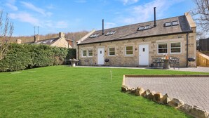 A stone house with a well-maintained lawn and outdoor seating area.