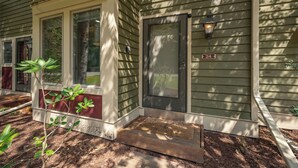 A house with a front porch, a door with a number plate, and a small plant. - New! Mountain View Chalet w/ Hot Tub & Fireplace (McHenry)
