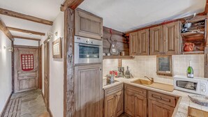A kitchen with wooden cabinets, a built-in oven, a microwave, and a sink. - 100m from ski slopes, balcony, tv, ski locker, 56m², Tignes (Tignes)