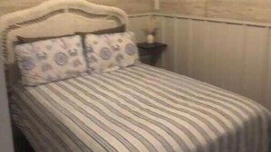 Una camera da letto accogliente e intima con un letto singolo, un comodino e una lampada a parete.