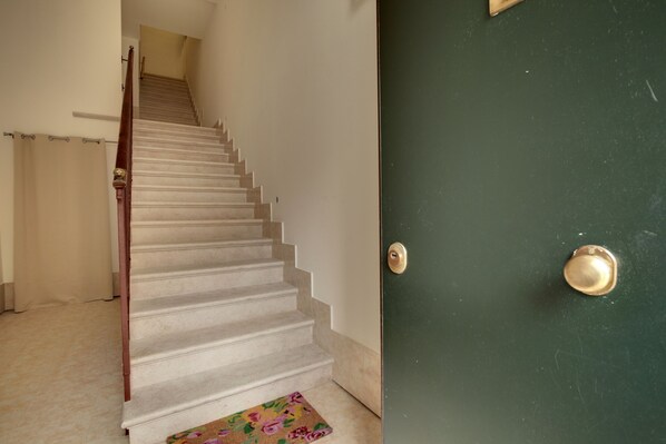 A staircase with a wooden handrail leading to a green door with a brass doorknob. - Accademia Opera Deluxe by Wonderful Italy (Venice)