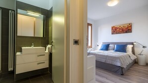 A modern bathroom with a large mirror, white cabinetry, and a visible radiator. - Arsenale Canal View 1 by Wonderful Italy (Venice)