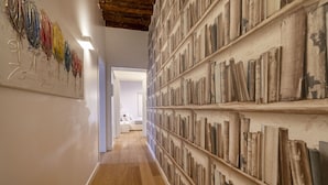 Een gang met houten vloer en boekenkasten vol boeken.