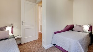 A bedroom with two beds, a white door, and an air conditioning unit on the wall. - Rugabella Rialto by Wonderful Italy (Venice)