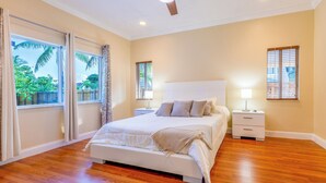 Una camera da letto con un letto grande, due comodini, una ventola a soffitto e vista sull'esterno.