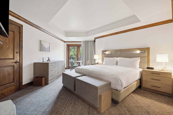 A hotel room with a large bed, a desk, a chair, and a view of the outdoors. - The Aspen Mountain Residences 24A - Studio Residence (Aspen)
