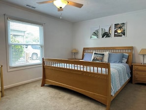 A bedroom with a wooden bed, a nightstand, a lamp, and a ceiling fan. - 3 Blocks to Beach - Sleeps 8 - 5 Bd - Pet Friendly (North Myrtle Beach)
